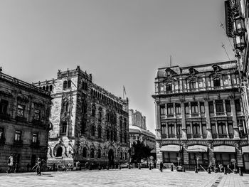 Buildings in city against clear sky