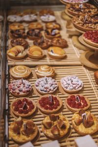 High angle view of dessert on shelf for sale at bakery