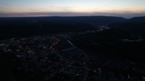 High angle view of illuminated cityscape against sky at sunset