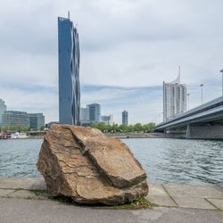 River by city buildings against sky