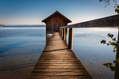 Wooden pier over sea against sky