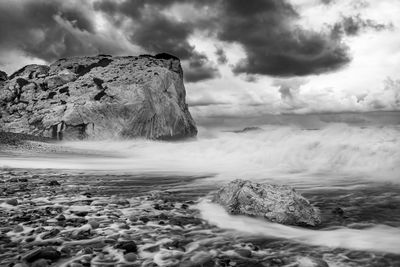 Scenic view of rocks in sea against sky