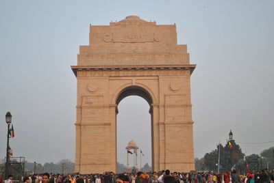 Tourists visiting india gate against clear sky