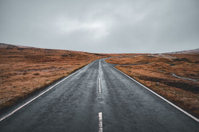 Road passing through landscape against sky