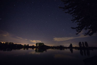 Scenic view of lake against sky at night