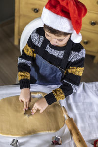 High angle view of boy making cookies at home