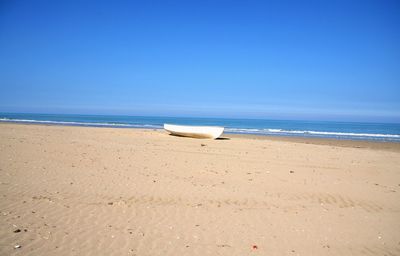 Scenic view of beach against clear blue sky