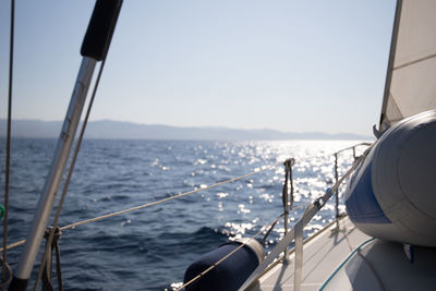 Sailboat sailing in sea against clear sky