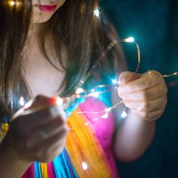 Close-up of hand holding illuminated lighting equipment