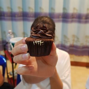 Close-up of mid adult woman hand holding cupcake