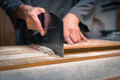 Midsection of chef cutting soba noodles on table