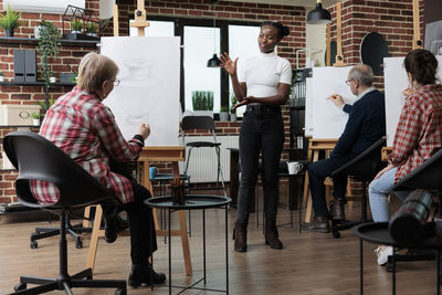 Female teacher teaching students during drawing class