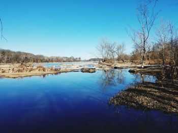 Scenic view of lake against clear blue sky