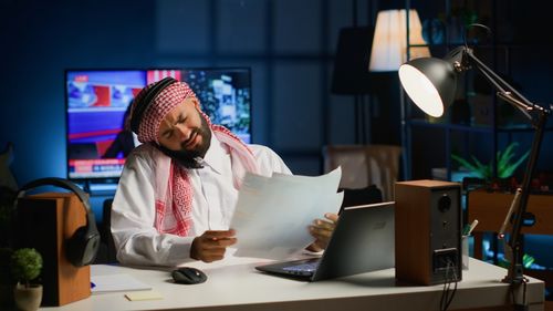 Side view of woman using laptop at office