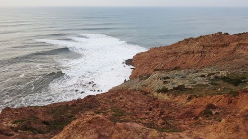 Rock formations on beach against sky