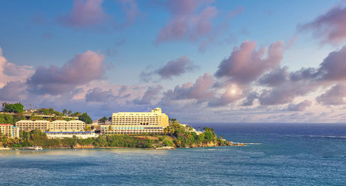 Scenic view of sea by buildings against sky