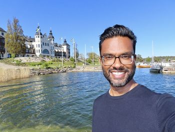 Portrait of smiling mid adult man against water