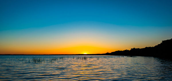 Scenic view of sea against clear sky during sunset