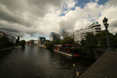 River amidst buildings in city against sky