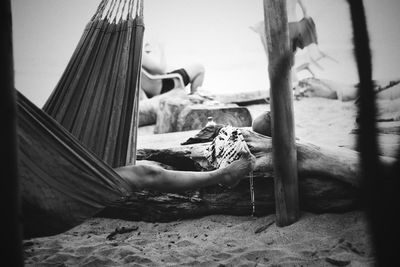 Low section of woman relaxing in hammock at beach