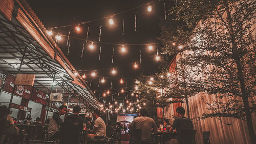 People on illuminated street at night