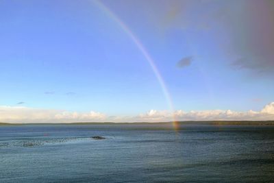 Scenic view of rainbow over sea against sky