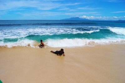 People at beach against sky