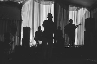 Rear view of silhouette people standing in front of building