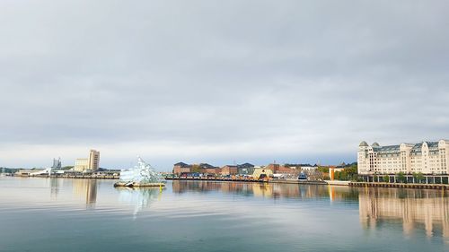 Buildings in city against cloudy sky