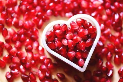 Close-up of pomegranate seeds in heart shape container