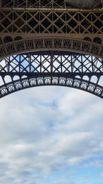 Low angle view of bridge against cloudy sky