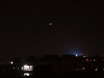 Illuminated cityscape against sky at night