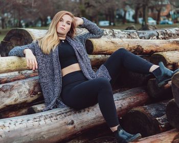 Close-up of woman posing on wooden logs