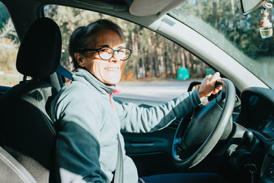 Side view of woman sitting in car