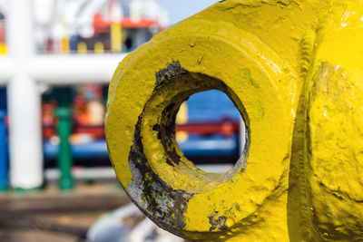 Close-up of yellow railing on pier