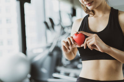 Midsection of woman holding strawberry while standing at home