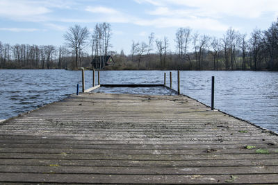 Wooden pier over lake against sky