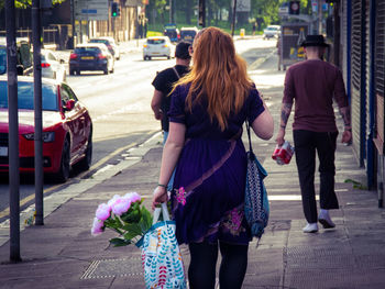 Rear view of women walking on road