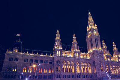Low angle view of illuminated building against sky at night