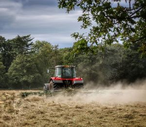 Tractor on field against trees