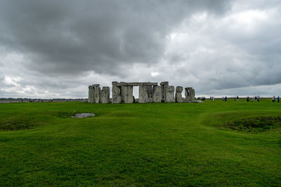 Old ruins on landscape against cloudy sky