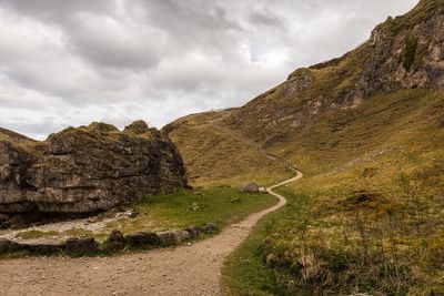 Road by mountain against sky