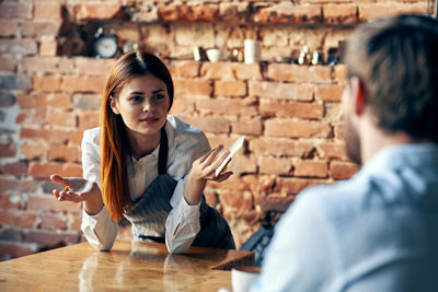 Rear view of couple sitting on table