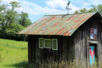 Abandoned house on field against sky