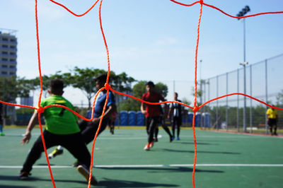 People playing soccer against sky