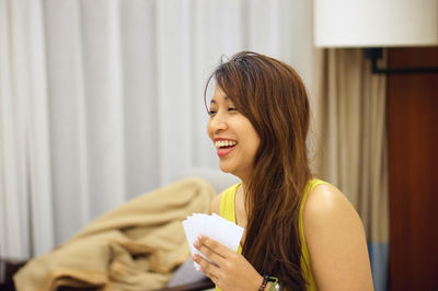 Close-up of young woman playing cards game at home