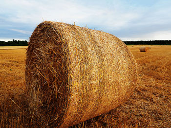 Hay bales on field against sky
