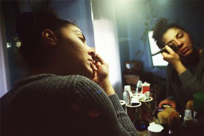 Young woman applying make-up