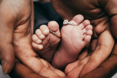 Close-up of father holding baby hand