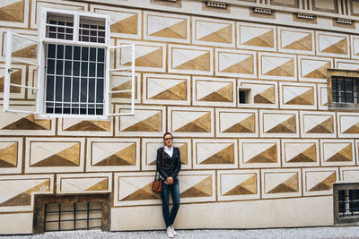 Full length of a woman standing against building